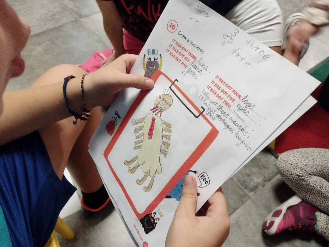 Niños trabajando juntos con una ficha ilustrada en el suelo del aula