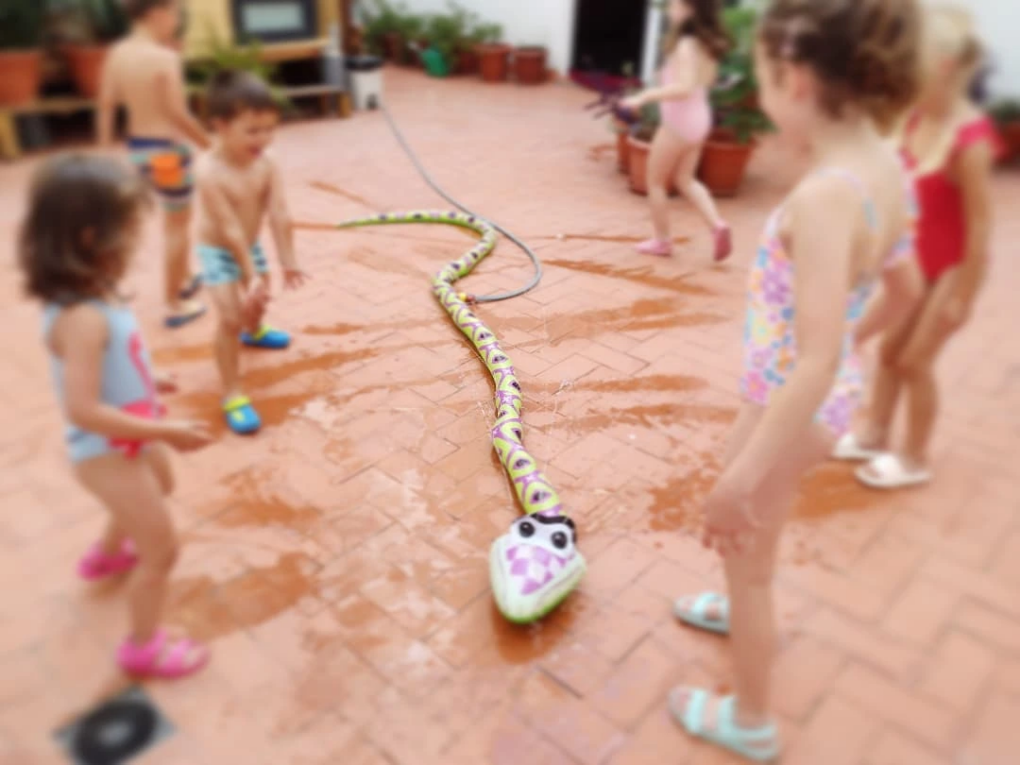 Niños jugando con agua en el patio durante la escuela de verano