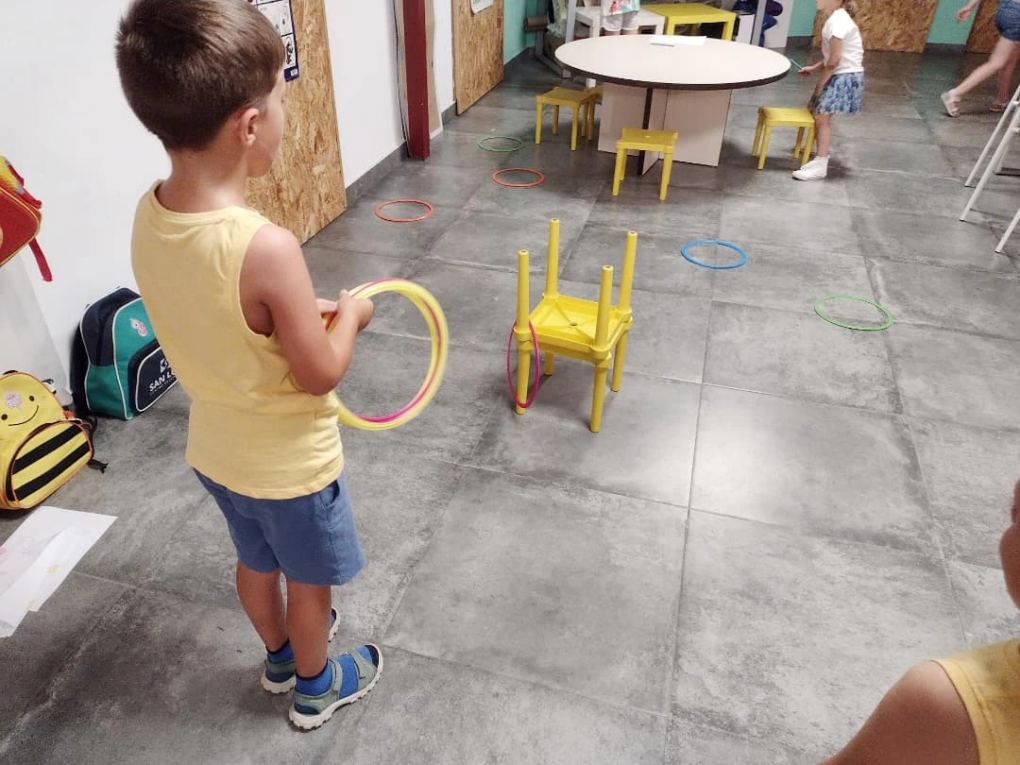 Niño jugando con aros de colores en la sala de actividades