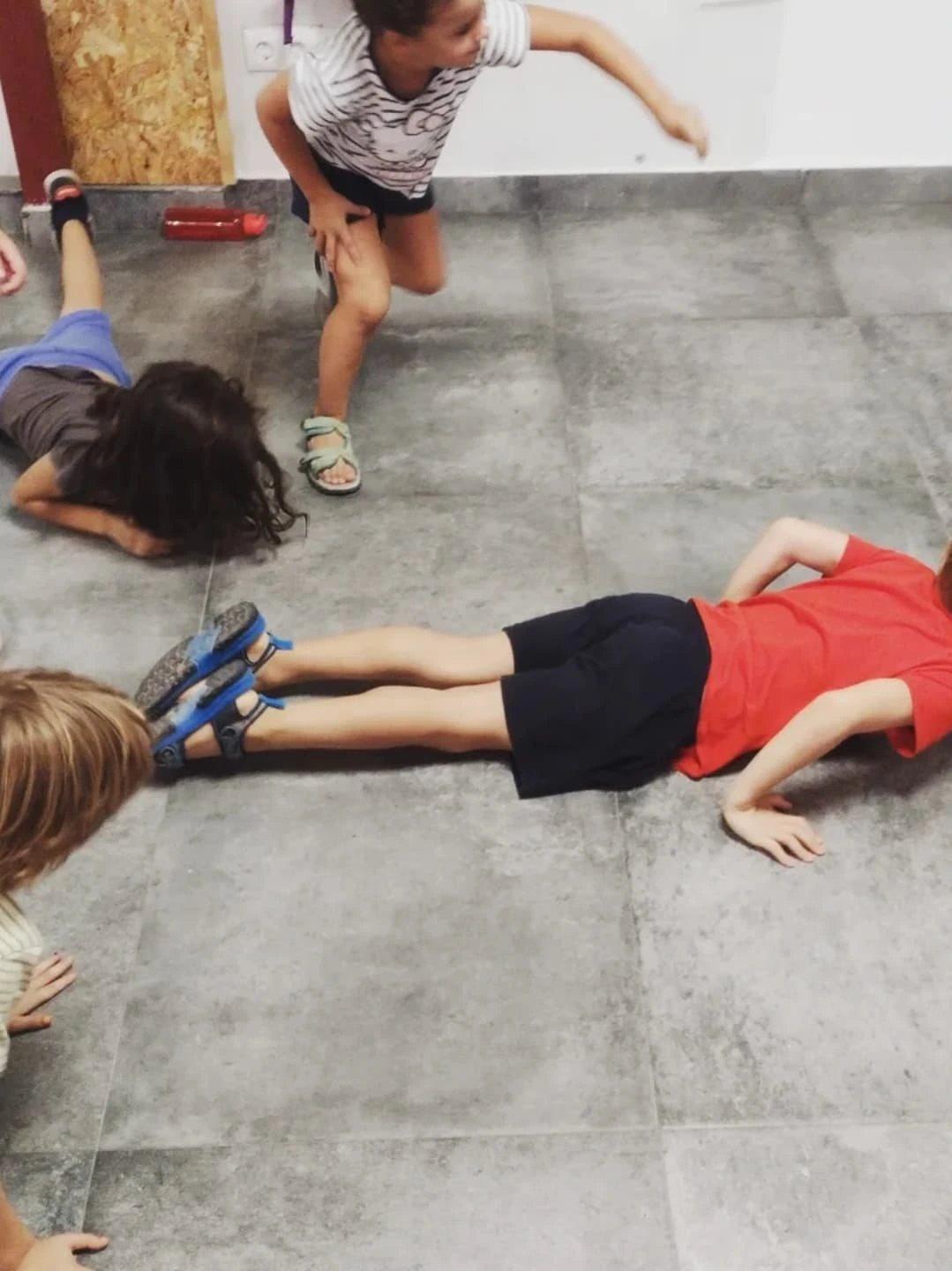 Niños haciendo ejercicio físico en el suelo del aula durante la clase