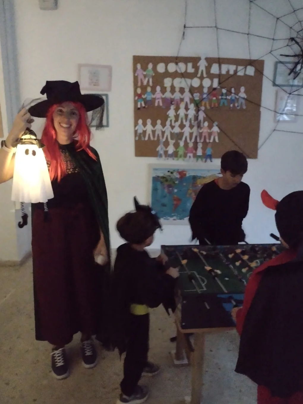Niños disfrazados celebrando Halloween en el aula decorada