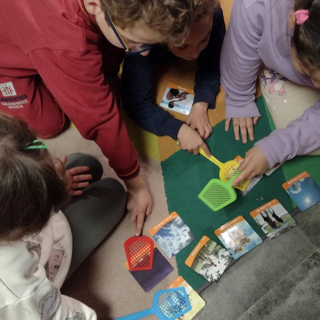 Profesora y niños jugando a un juego de mesa educativo en el suelo